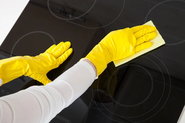 Housewife cleaning an induction plate — Stock Photo, Image