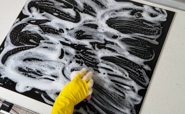 Housewife cleaning an induction plate