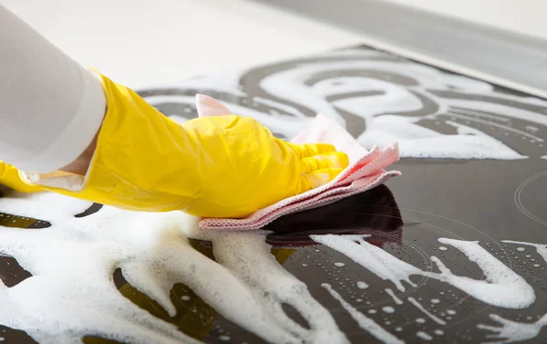 Домохозяйка чистит индукционную пластину — стоковое фото