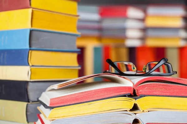 Opened book and glasses on colored background — Stock Photo, Image