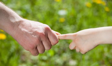 İnsan ve çocuk bir arada tutan eller 
