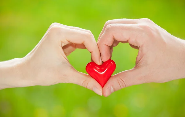 La mano del hombre proponiendo un corazón rojo — Foto de Stock