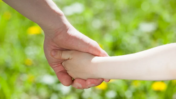 Ребенок держит отца за руку — стоковое фото