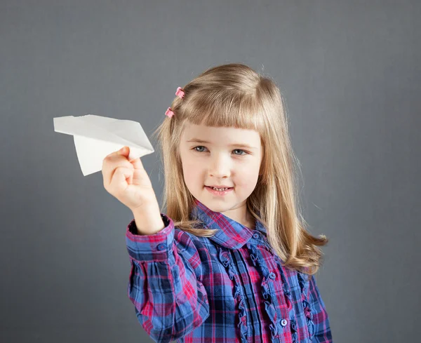 Uśmiechający się mała dziewczynka latający papierowy samolot — Zdjęcie stockowe