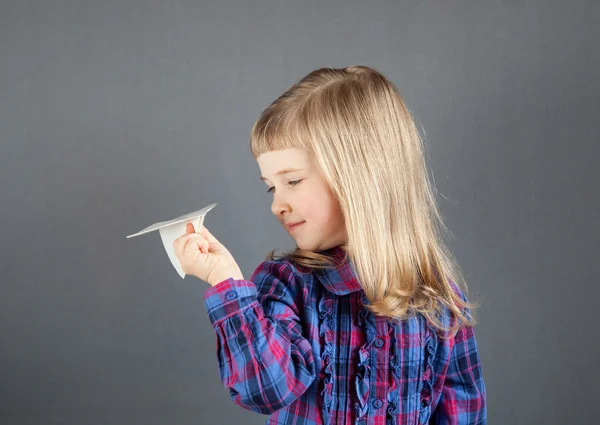 Smiling little girl flying paper plane — Stock Photo, Image