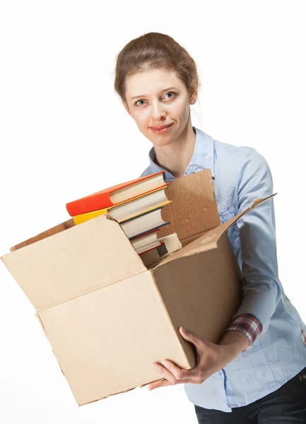 Femme souriante portant une boîte avec des livres — Photo