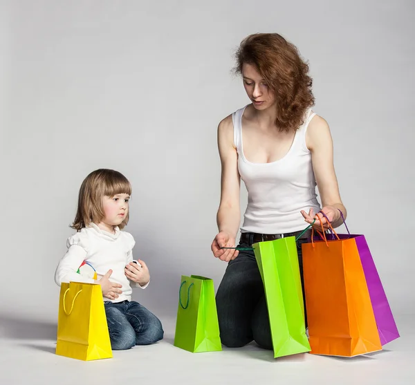 Menina e sua mãe com sacos de compras — Fotografia de Stock