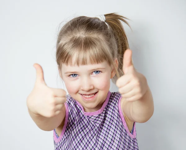 Usměvavá holčička ukazuje palec — Stock fotografie