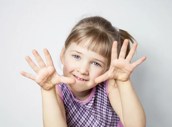 En söt liten flicka som visar händerna. — Stockfoto