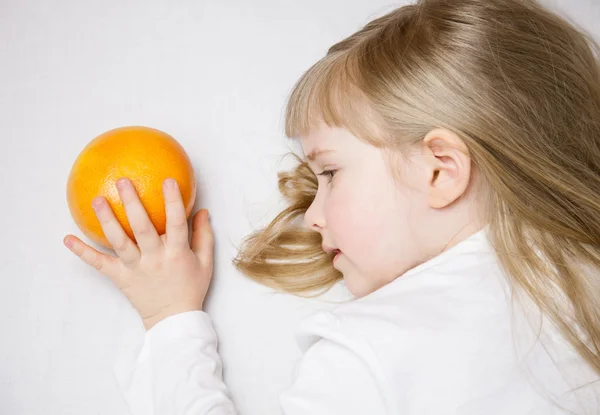 Bedårande liten flicka med mogen grapefrukt — Stockfoto