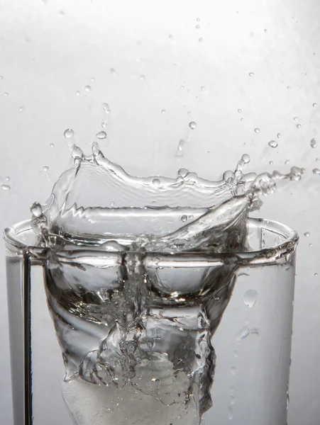 Water en stuk ijs in glas — Stockfoto