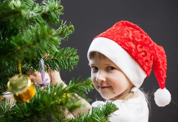 女の子はクリスマスツリーを飾る — ストック写真