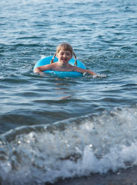 Grappige ittle meisje zwemmen met opblaasbare cirkel — Stockfoto