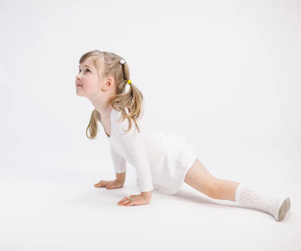 Smiling little girl doing the splits — Stock Photo, Image