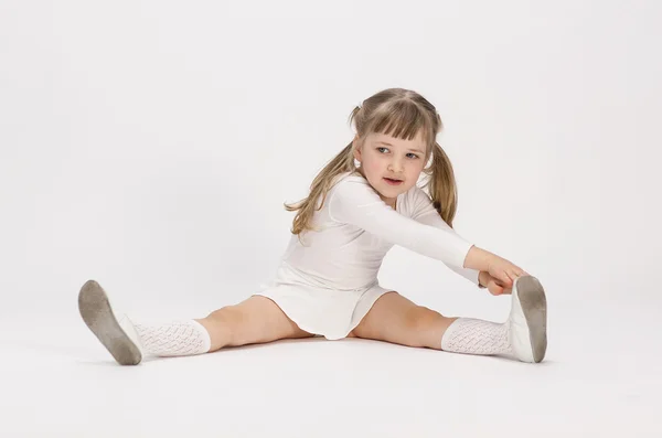 Niña sentada haciendo ejercicio —  Fotos de Stock