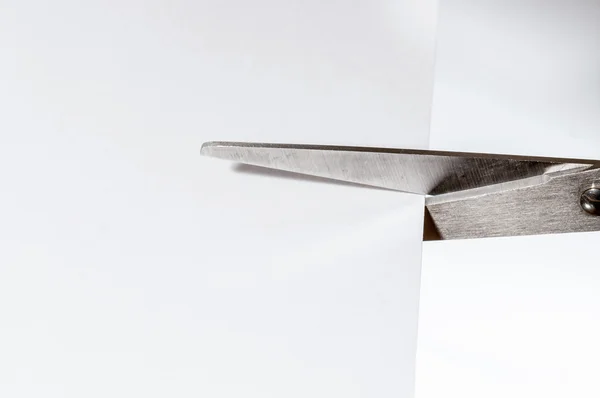 Scissors cutting a white paper — Stock Photo, Image