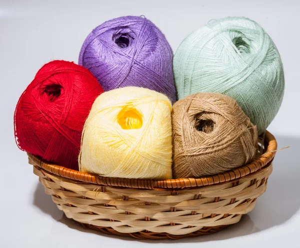 Skeins of yarn in a braided basket — Stock Photo, Image