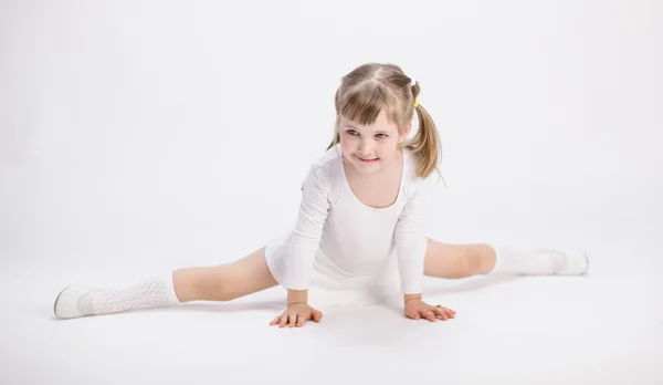 Souriante petite fille qui fait les fentes Images De Stock Libres De Droits