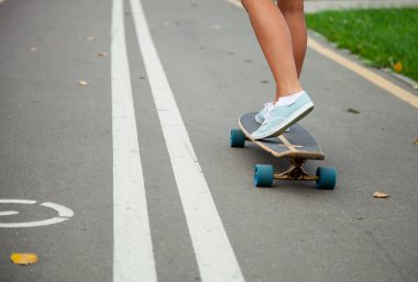 Tanınmayan kız bir longboard üzerinde paten 