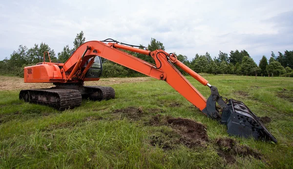 Grävmaskin arbetar på ett fält — Stockfoto
