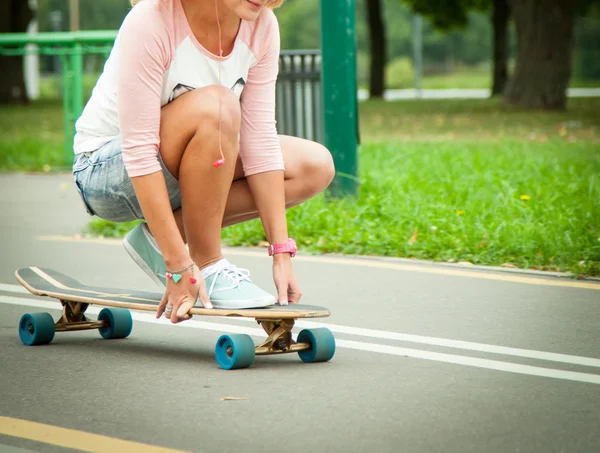 Fille assise sur un longboard — Photo