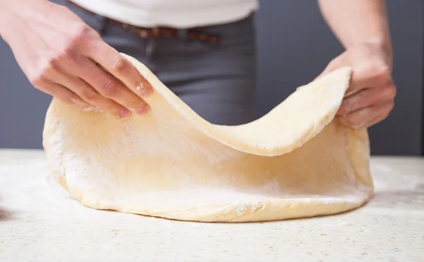 Vrouw handen uitrekken deeg — Stockfoto