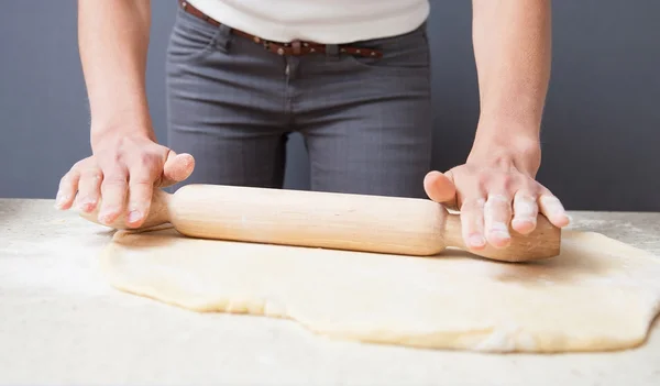 Hausfrau glättet Teig mit Nudelholz — Stockfoto