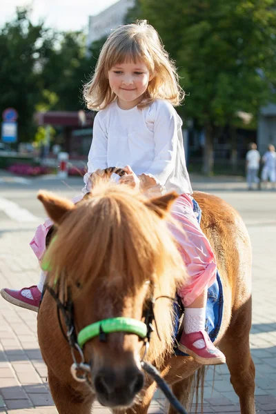 Happy little girl on a pony — Stock Photo, Image