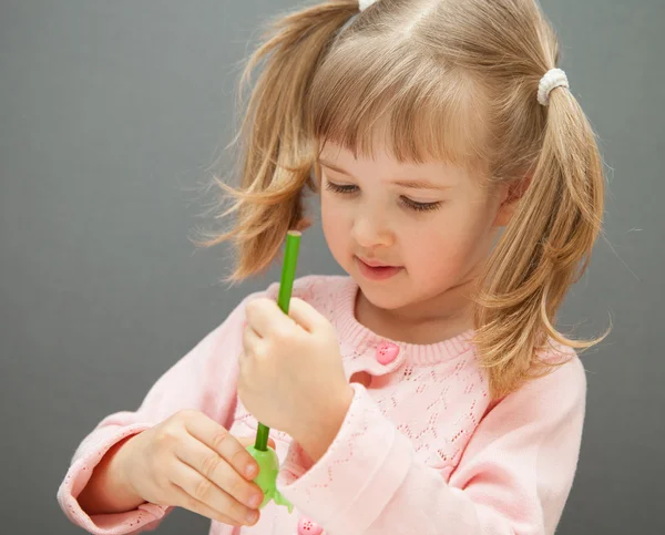 Menina afiando um lápis verde — Fotografia de Stock