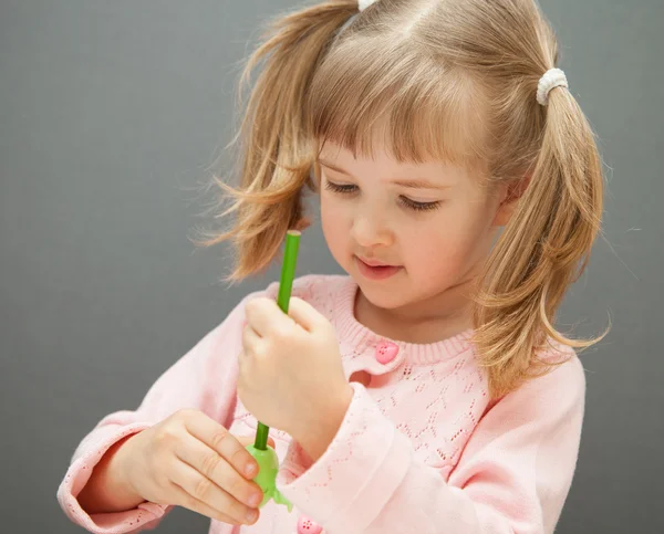 Ragazza che affila una matita verde — Foto Stock