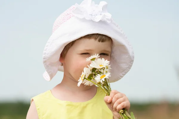 Little girl smelling summer flowers — Stock Photo, Image