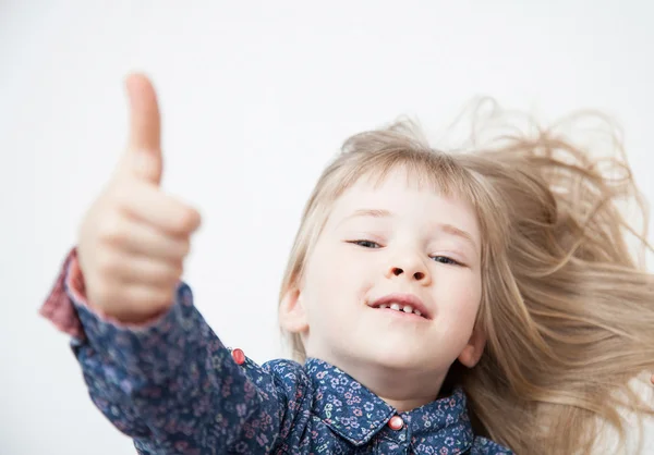Usměvavá holčička ukazuje palec — Stock fotografie