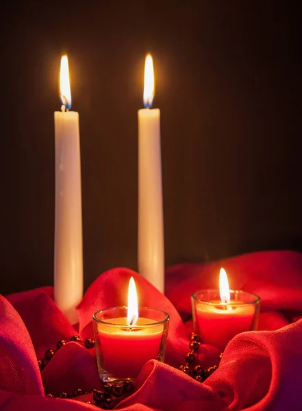 Hermosas velas en tela roja — Foto de Stock