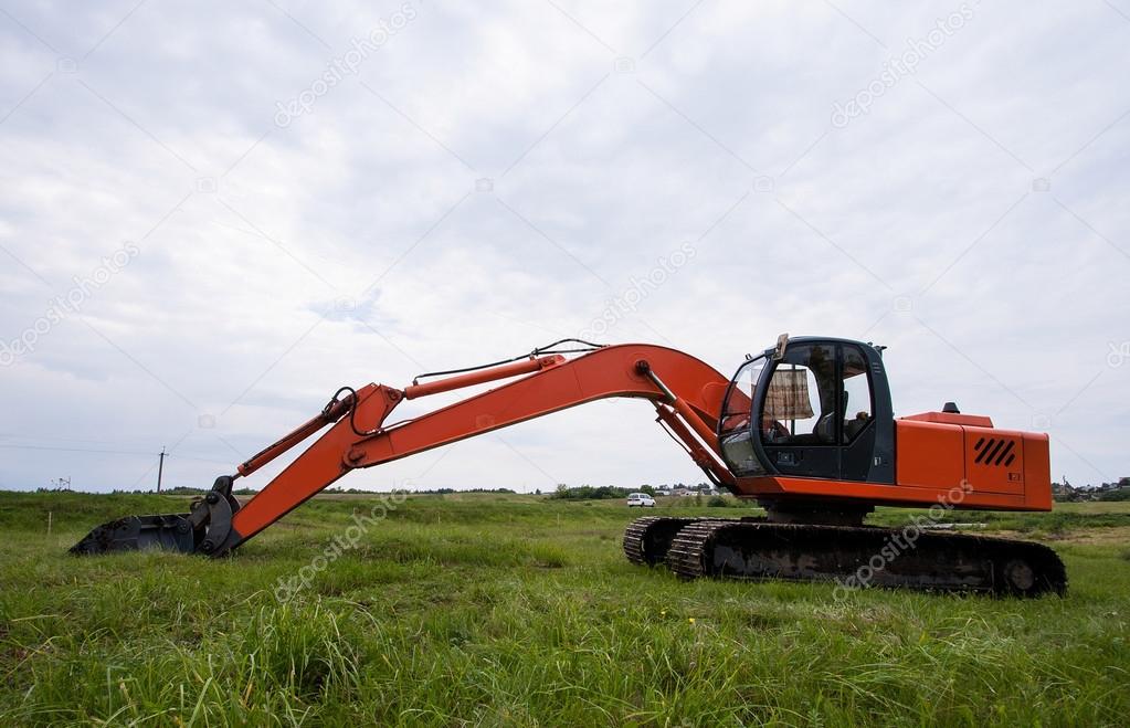 Excavator working  on a field