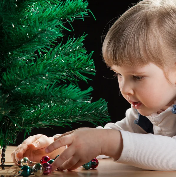 Klein meisje versiert de kerstboom — Stockfoto