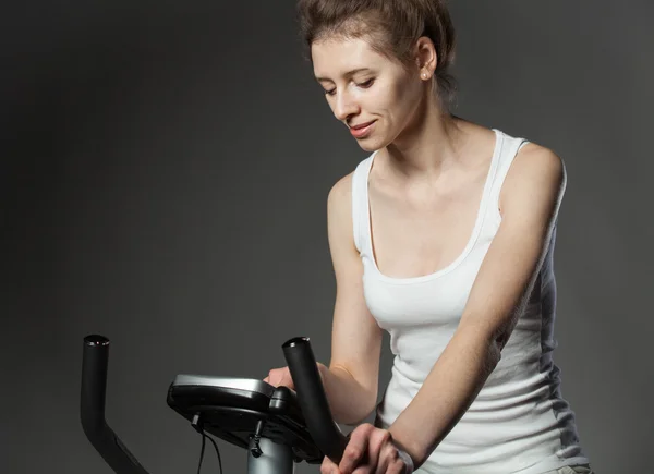 Woman on a training bicycle — Stock Photo, Image