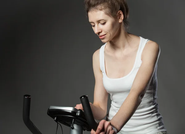 Donna su una bicicletta da allenamento — Foto Stock