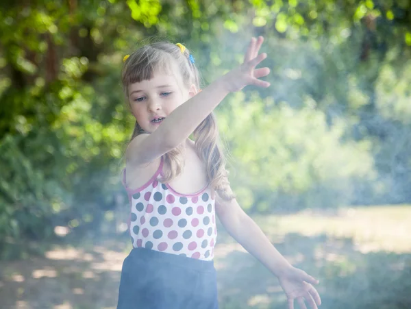 Little girl dispersing smoke — Stock Photo, Image