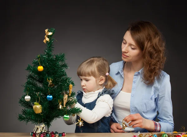 Dívka a její maminka zdobí vánoční strom — Stock fotografie