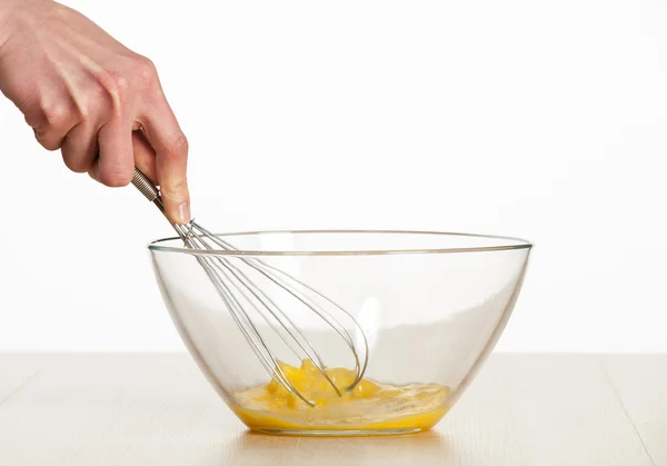 Whipping eggs with a metal whisk — Stock Photo, Image