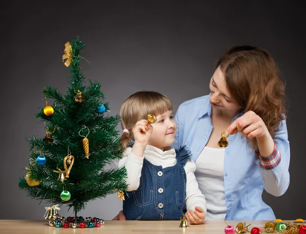 Mädchen und ihre Mumie schmücken den Weihnachtsbaum Stockbild