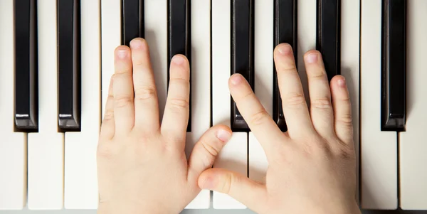 Van het kind handen spelen de piano — Stockfoto