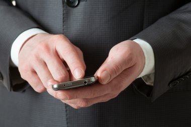 Tanınmayan işadamı bir cep telefonu tutan