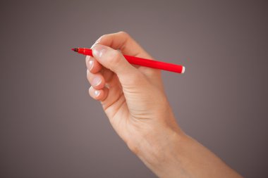 Kırmızı keçeli kalem tutan el 