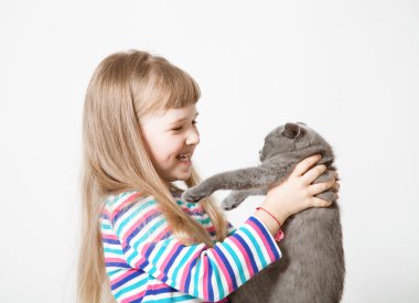 Bir kedi tutan mutlu küçük kız 