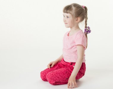 Kız yerde oturuyor.