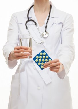 Bir bardak su ve tablet tutan doktor