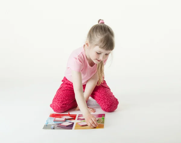 Affascinante bambina che gioca sul pavimento — Foto Stock