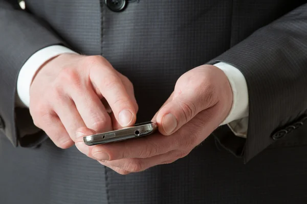 Empresário irreconhecível segurando um celular — Fotografia de Stock