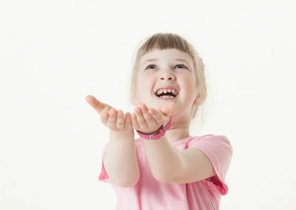 Glückliches kleines Mädchen, das seine Handflächen ausstreckt und etwas fängt — Stockfoto